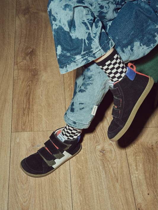 Kind trägt Mikusasa Barfußsneaker Sana mit Klettverschluss